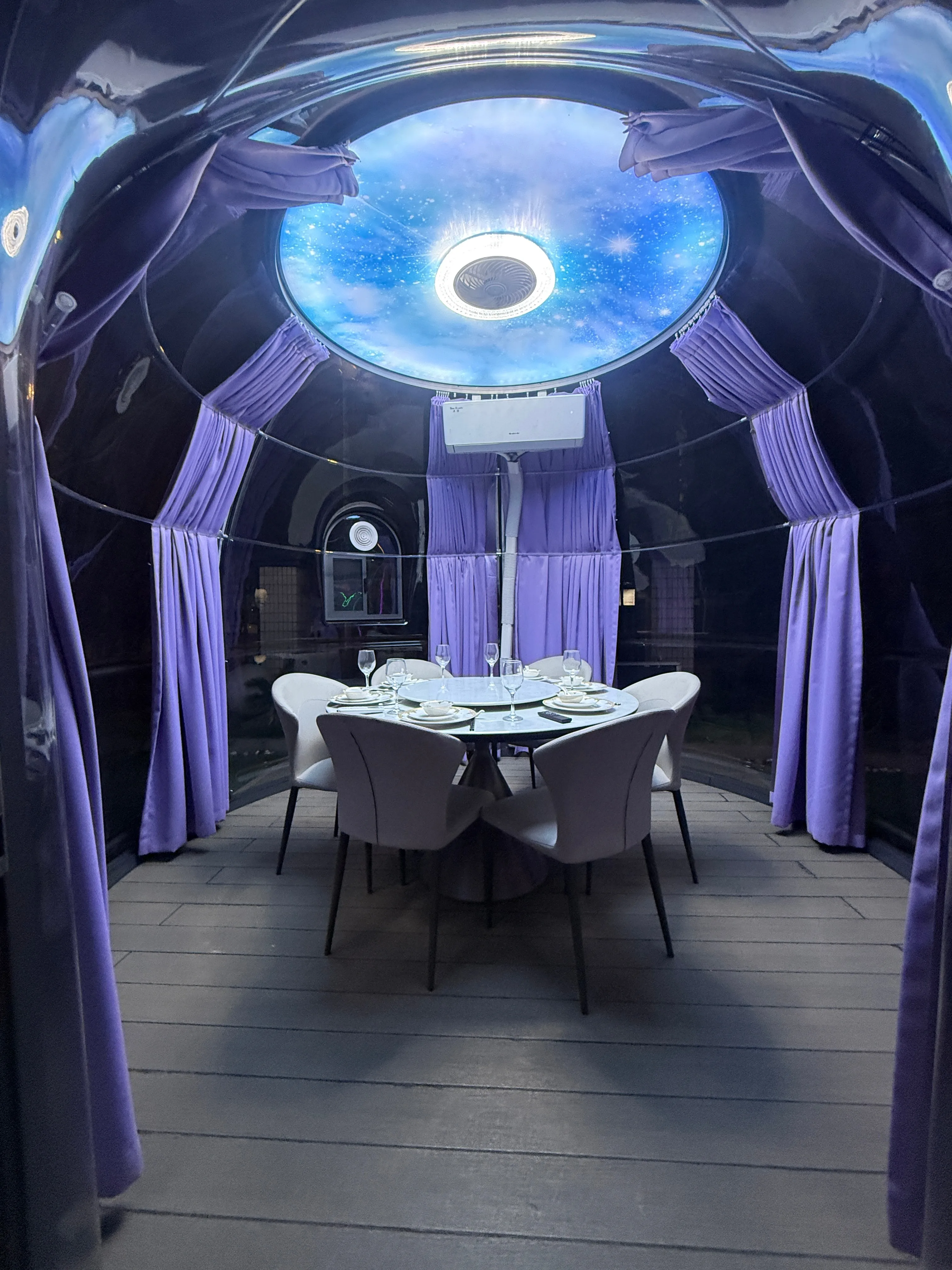 Starry sky dome restaurant at night with warm interior lighting
